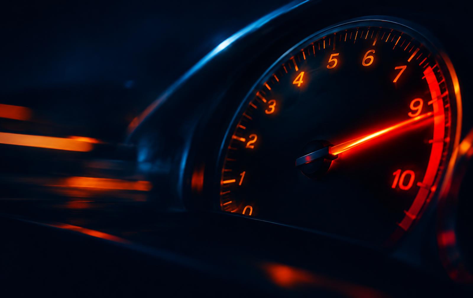 Car tachometer needle glowing at redline